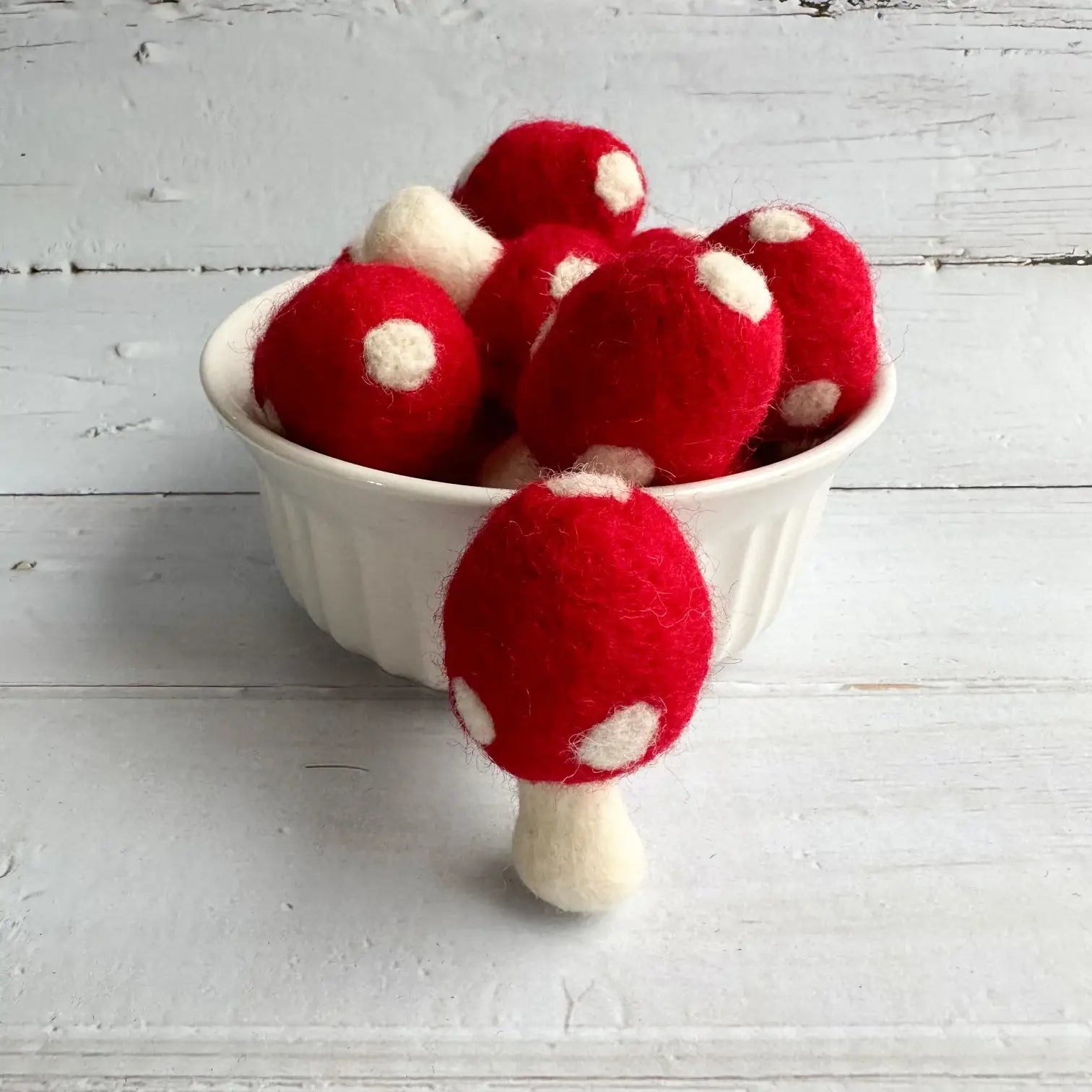 Felt red mushrooms in a bowl